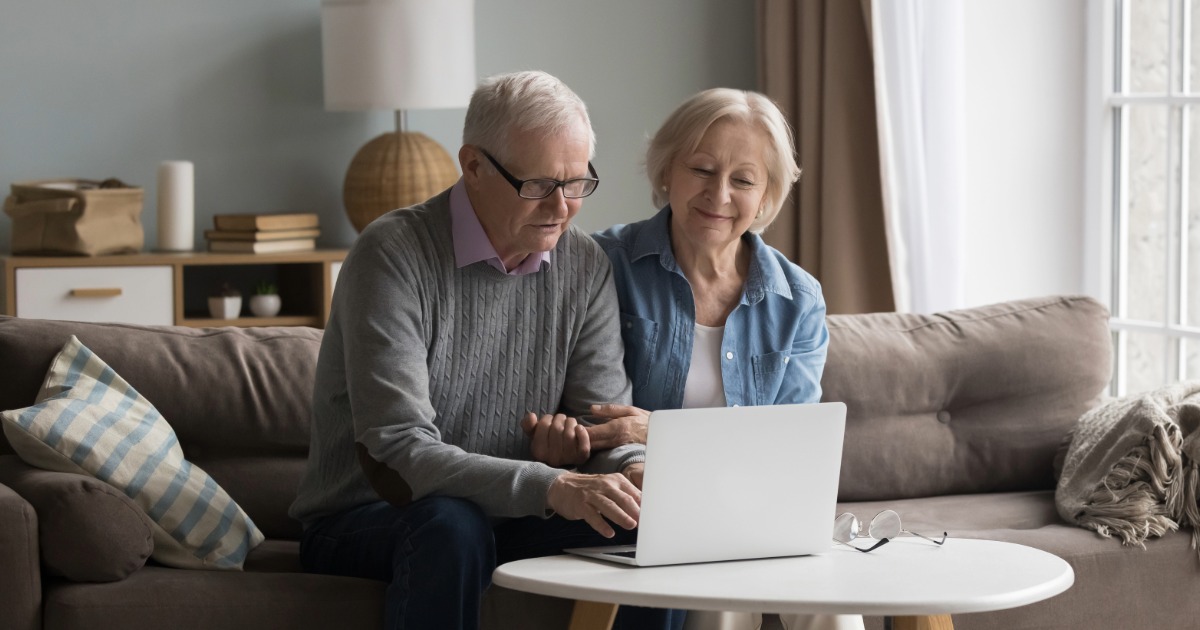 Elderly couple on the sofa looking at a laptop screen