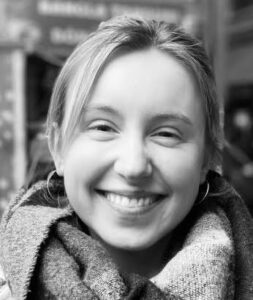 Smiling woman wearing a scarf, looking at the camera (black and white photo).